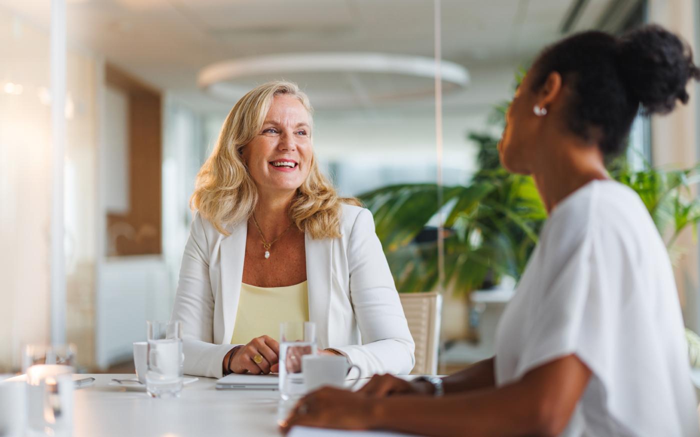 Two people sitting at a table, smiling at each other